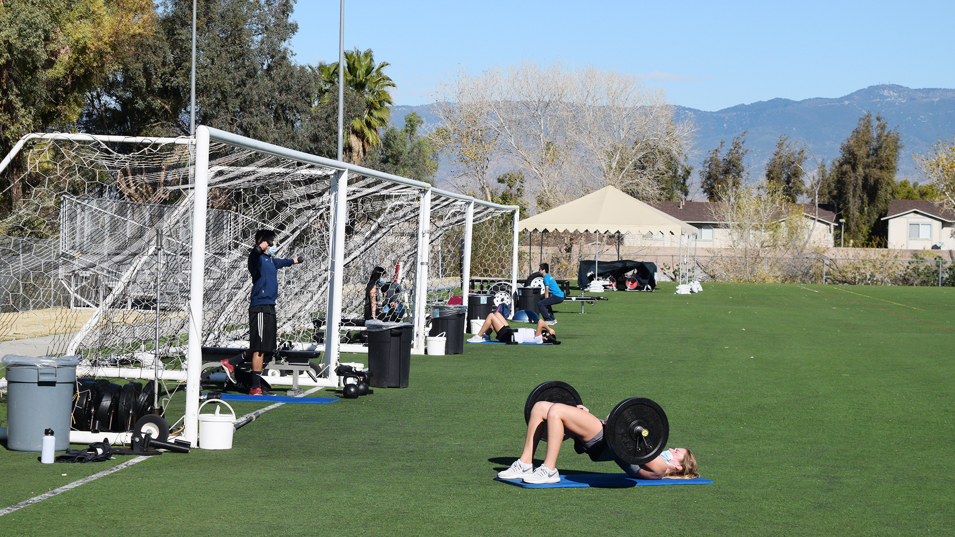 LLUH members use exercise equipment on turf field