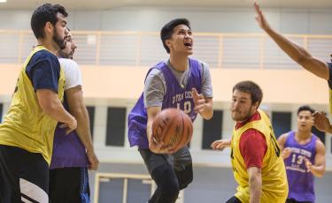 man playing basketball game with basketball in hand