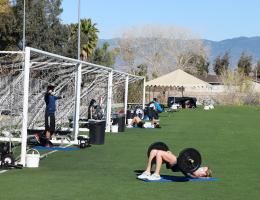 LLUH members use exercise equipment on turf field